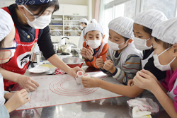 「女性部員が小学生児童とやしょうまつくる」の画像